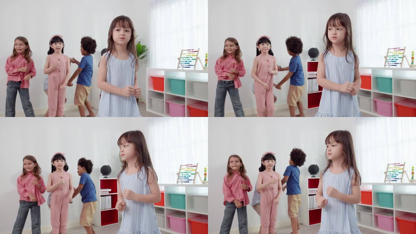 可爱的亚洲六岁学生女孩穿着蓝色条纹连衣裙，在朋友面前跳舞，两个可爱的小男孩牵着手，欢快地跳跃着。