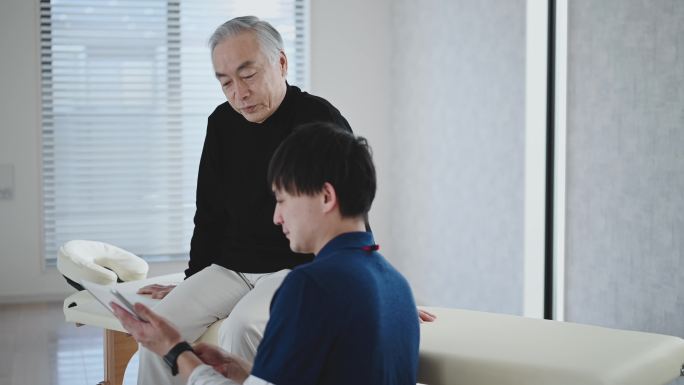 物理治疗师检查并为老年男性患者提供建议。