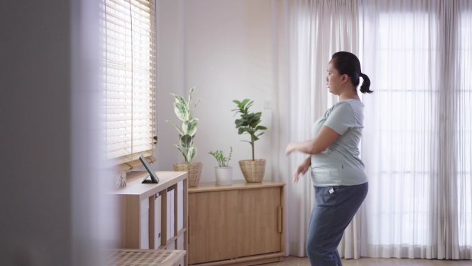 女性在家通过平板电脑节食锻炼和观看锻炼教程