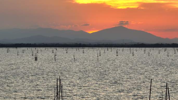 泰国宋赫拉省日落时分，空中无人机在宋赫拉湖上空带着捕鱼设备和养鱼