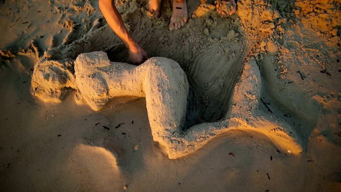 海滩上用沙子做成的美人鱼。雕塑家和他的行为