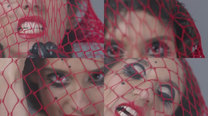 可爱的黑发时尚模特被困在红色网中，露出面部表情。时尚视频。