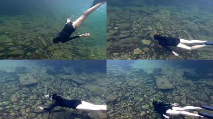 亚洲女子自由潜水员在清澈的水中。