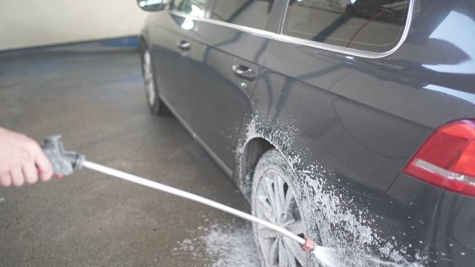 男性在洗车时在车上喷洒雪沫