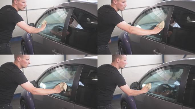 男性擦拭车窗并在清洗后干燥整个车辆