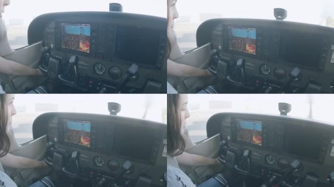 在一架小型单引擎飞机上，年轻的成年女飞行员启动起动机转动螺旋桨
