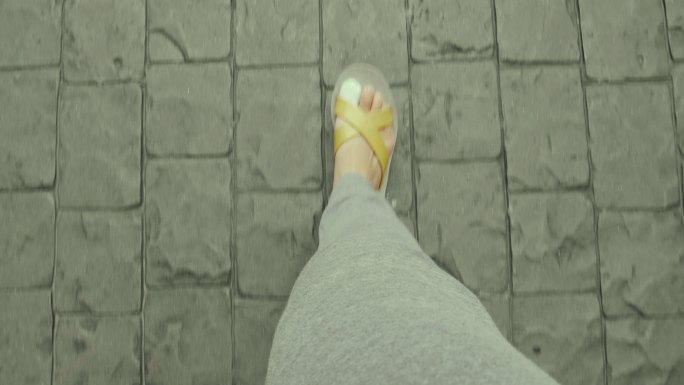 穿着凉鞋走路时脚趾疼痛的脚的POV