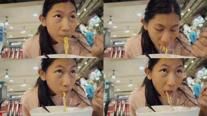 亚洲女孩在美食广场吃热面汤作为午餐，生活方式理念