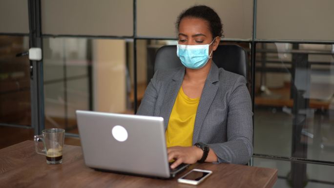 新冠肺炎疫情期间，女商人在办公室戴着防护口罩