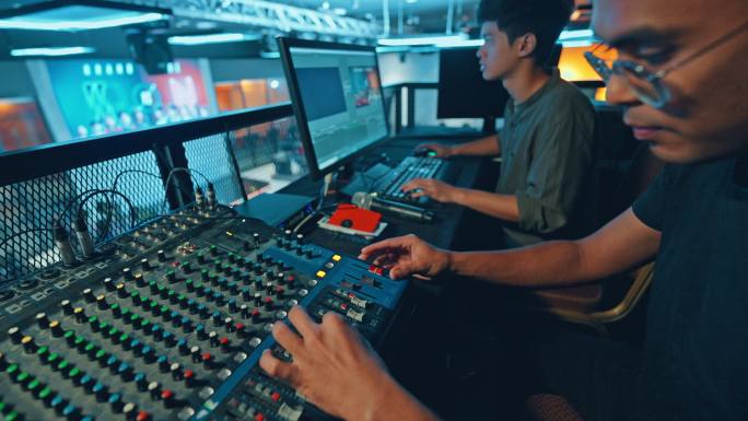 亚洲体育赛事工作人员在后台工作，控制舞台灯光、音响系统和灯光效果