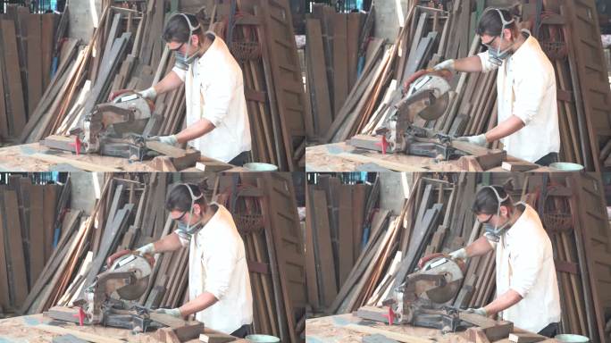 木匠在车间工作。他在锯木板。