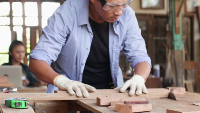 小企业主木匠用圆锯锯木头。