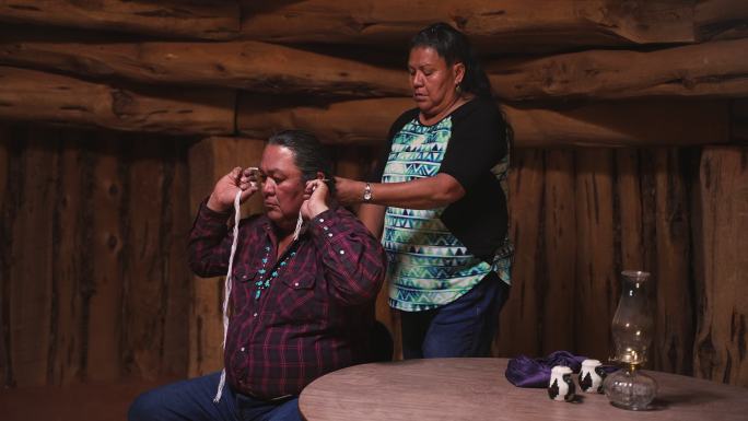 妻子在传统的纳瓦霍霍根（navajo hogan）内为丈夫做头发-传统