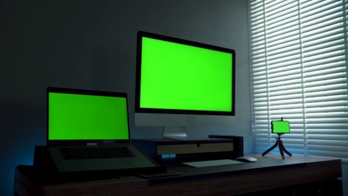 多个显示器在昏暗的房间中显示绿色屏幕。