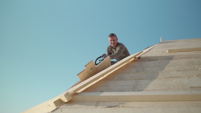 使用电锯进行屋顶施工的专业工人