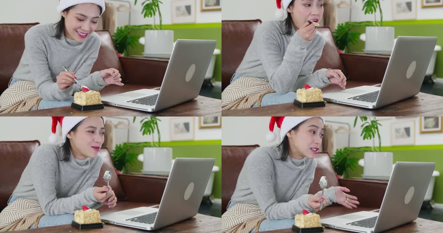美女戴着圣诞帽看电脑视频聊天吃蛋糕