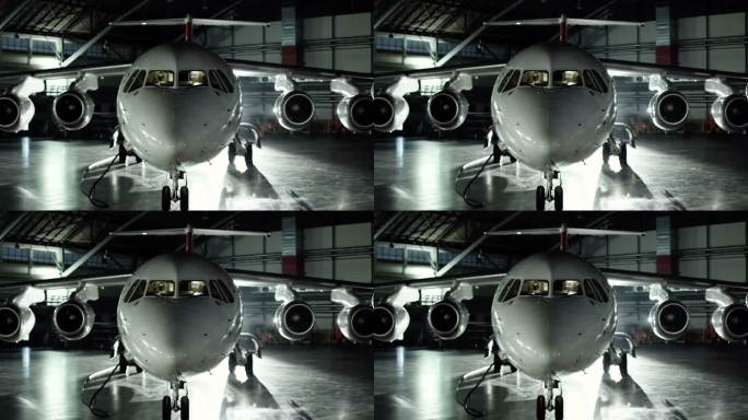 飞机库中的飞机，从飞机的前视图和窗户发出的光线。库存照片