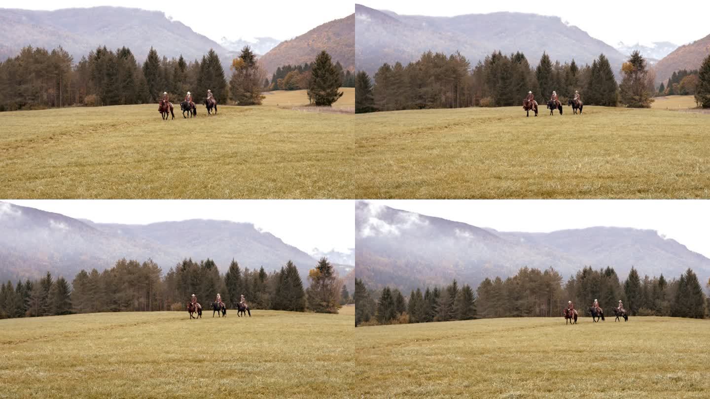 三个人骑马在山间草地上