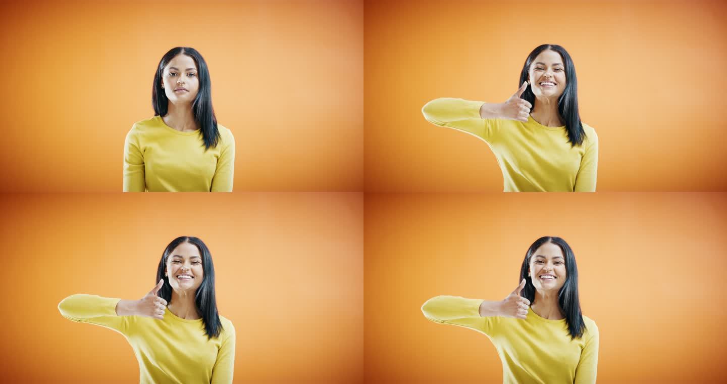 一名年轻女子在橙色摄影棚背景下竖起大拇指的4k视频片段