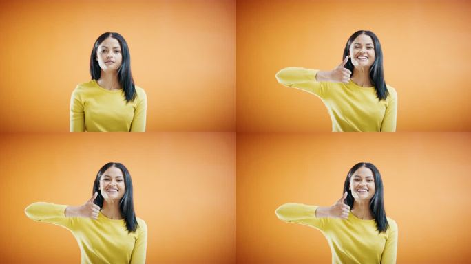 一名年轻女子在橙色摄影棚背景下竖起大拇指的4k视频片段