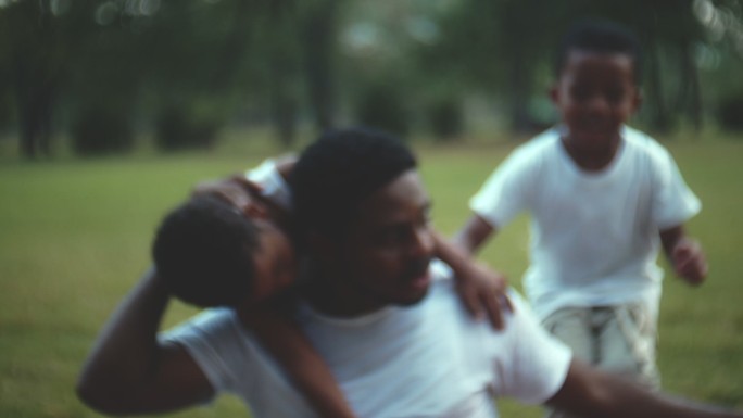 可爱的家庭黑人家庭孩子奔跑拥抱父亲草地父