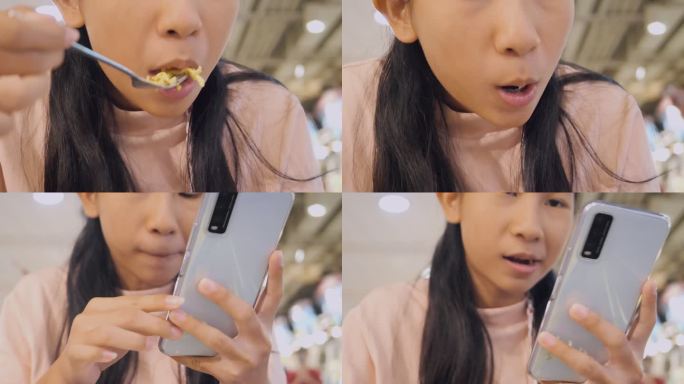 亚洲女孩吃着热面汤，在美食广场用智能手机吃午餐，生活方式理念