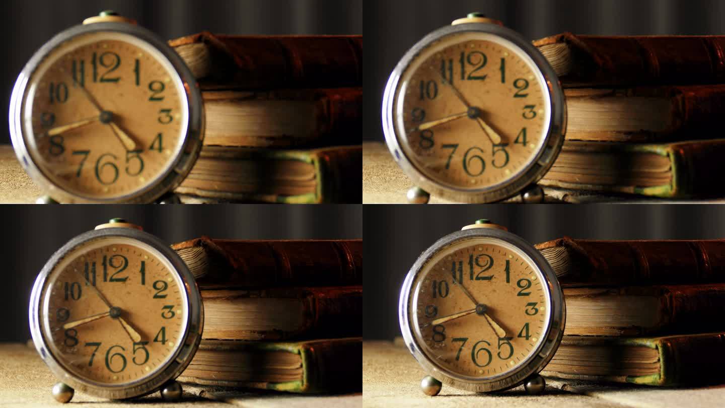 木制桌子上有旧皮革封面书的复古闹钟