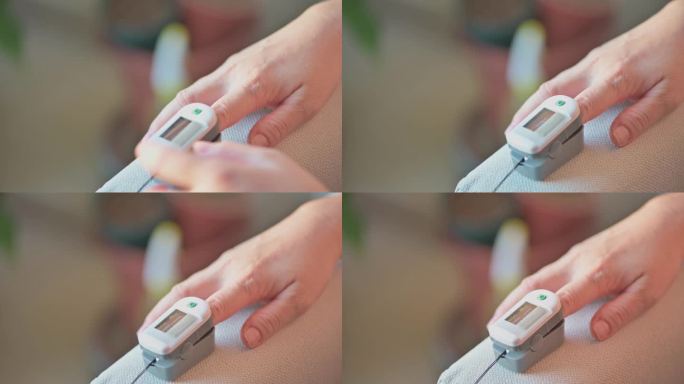 近距离接触亚洲中国中年女性的手指，并附上血氧饱和度计，在家中测量血氧饱和度和心率COVID-19健康
