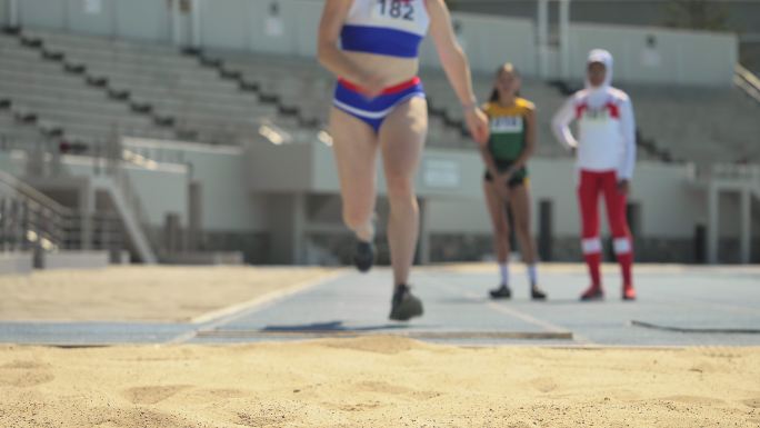 女子田径运动员沙滩跳远