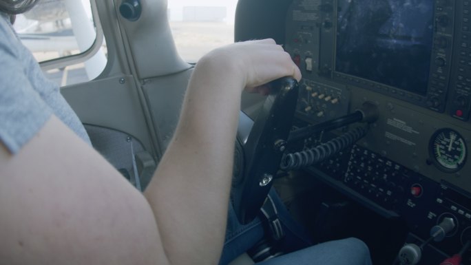 年轻成年女飞行员检查小型单引擎飞机飞行控制装置的运动范围