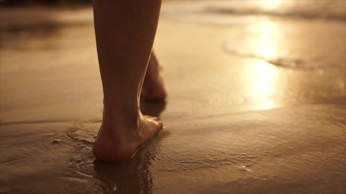 日落时分，一个身材矮小的女人在海边散步的美丽场景