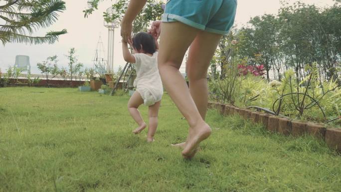 亚洲母亲帮助女儿学习走路