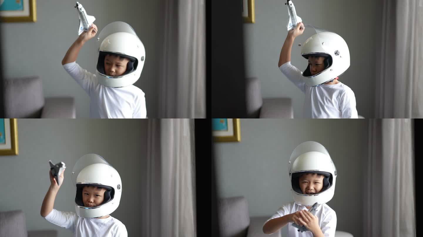 一个亚洲男孩玩着游戏，用地球仪和宇宙飞船假装宇航员。梦想未来和灵感的概念