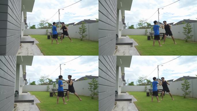 亚洲中国少年在家后院与父亲一起训练武术