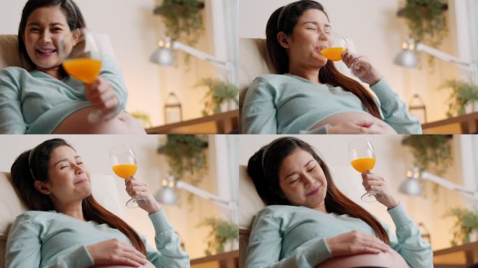 特写美丽的幸福和微笑的孕妇在家喝橙汁。