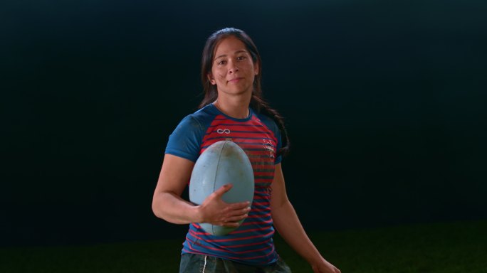 SLO MO一位微笑的女橄榄球运动员拿着球的肖像