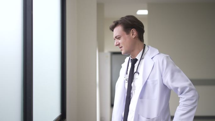 紧张的医生站在窗前。