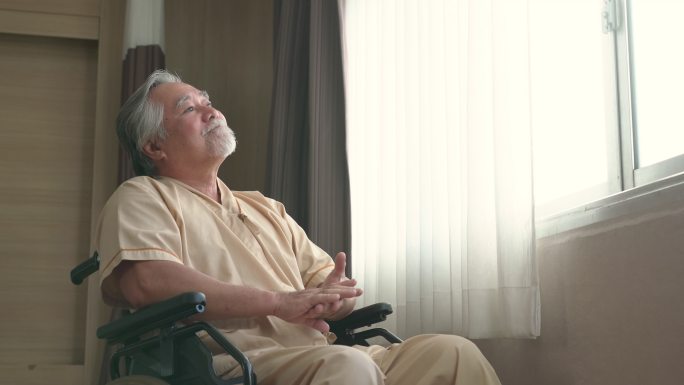 坐在医院病房轮椅上的快乐老人