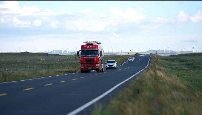 航拍夕阳 草原公路上 行驶的货车