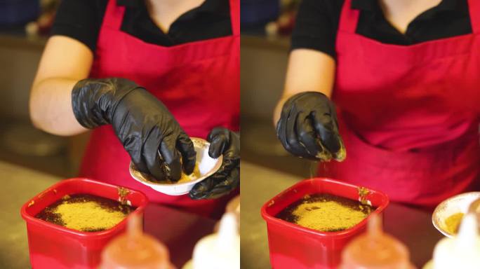 一名餐厅员工将酱油放在一个小盘子上