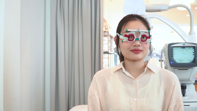 亚洲年轻女性在从验光师那里获得合适的镜片后，戴上光学试验架，测试视力表、斯奈伦视力表，准备戴光学眼镜