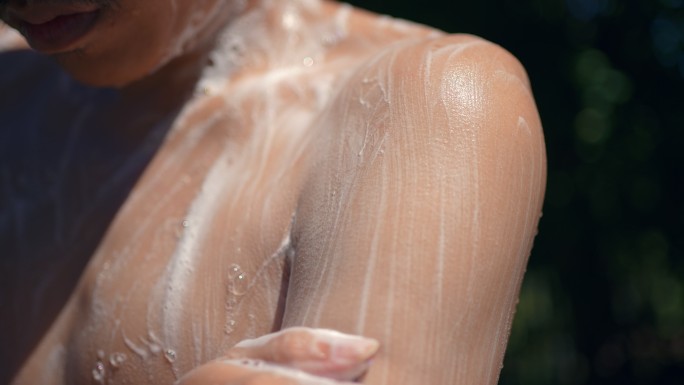 慢镜头：男子在室外花园洗身体