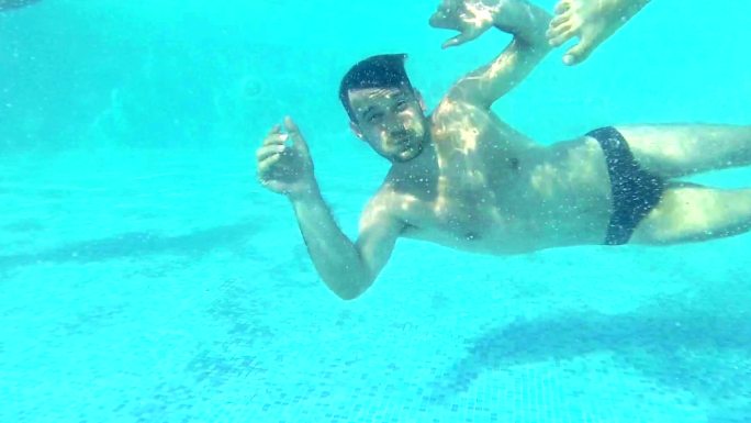 水下乐趣。外国人泳池潜水游玩美女比基尼朋