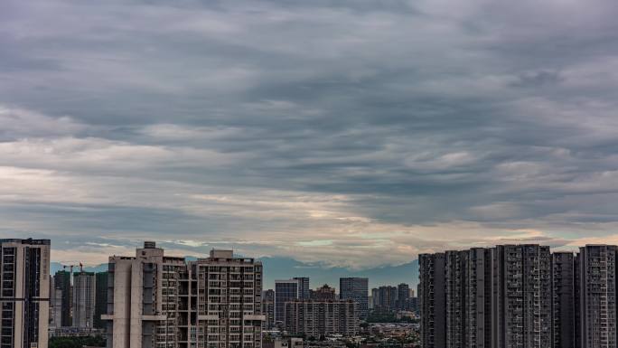 城市天空厚重乌云城市与山延时雪山下的城市