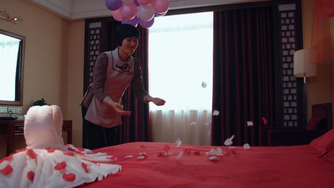 酒店工作人员布置婚房绑气球放喜糖喜果