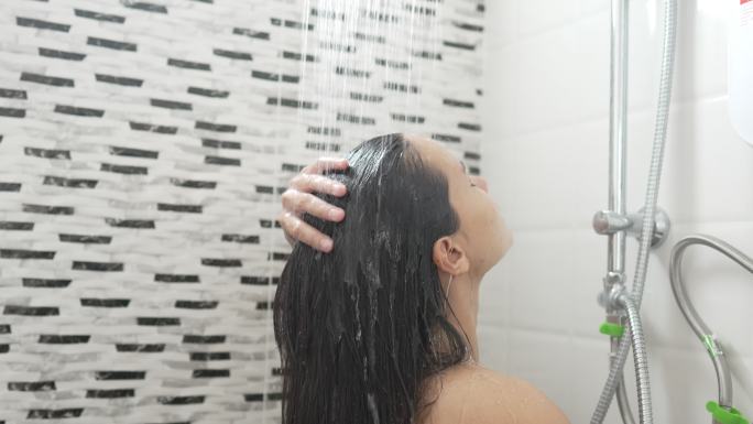 年轻女子在浴室里淋浴和洗头