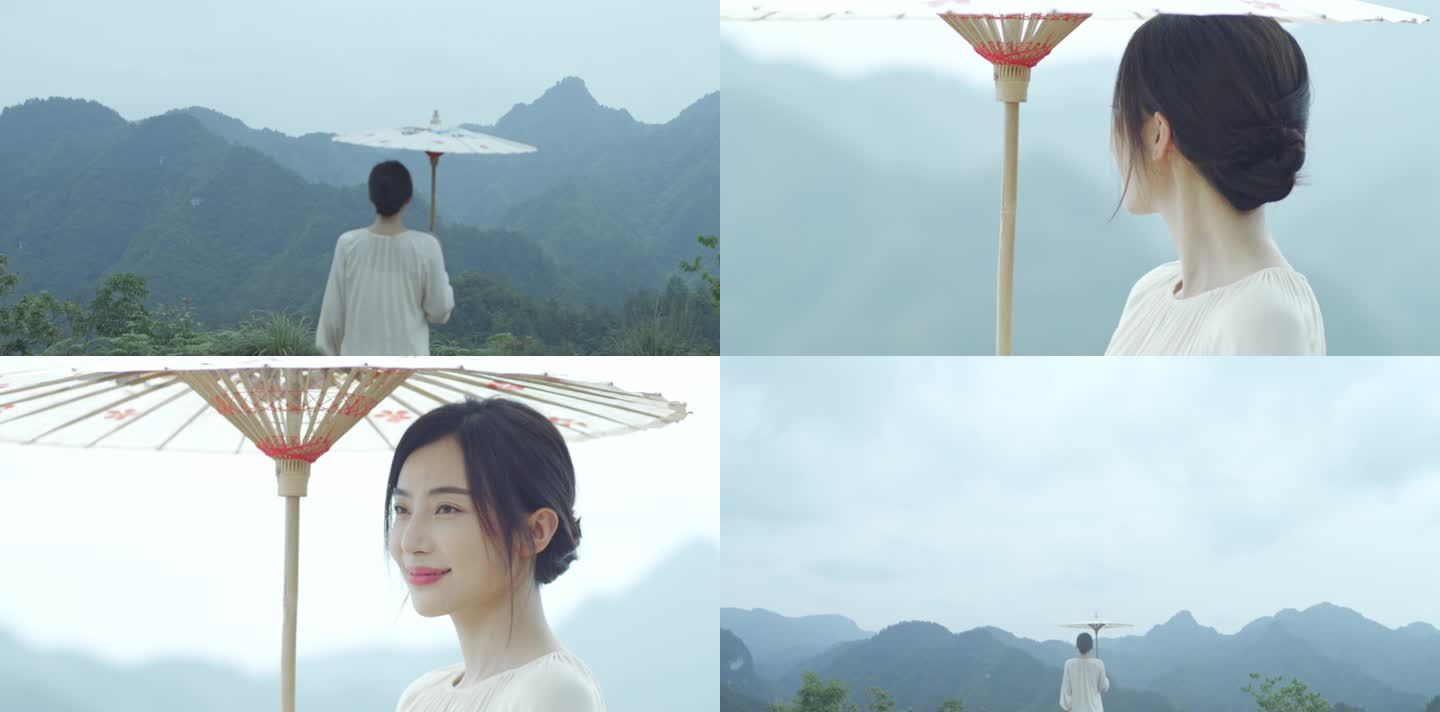 少女打着纸伞在山顶行走