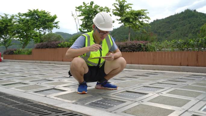 技术人员检查安装在道路上的太阳能电池板