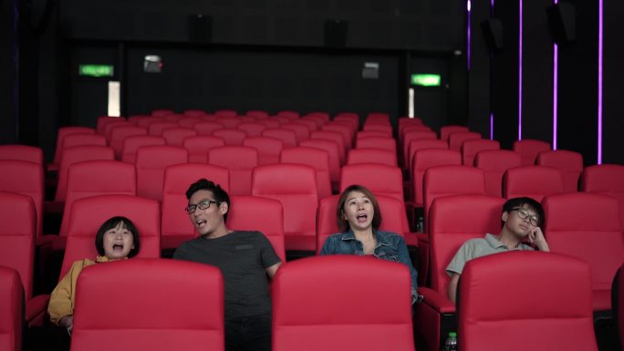 亚洲中国家庭周末在电影院观看恐怖电影。