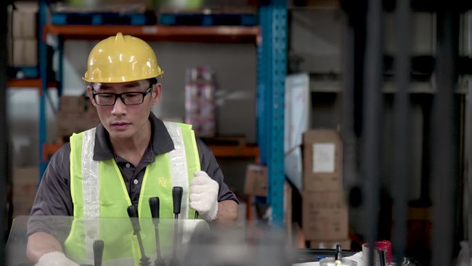 亚洲中国仓库工人在工业工厂使用叉车搬运货物